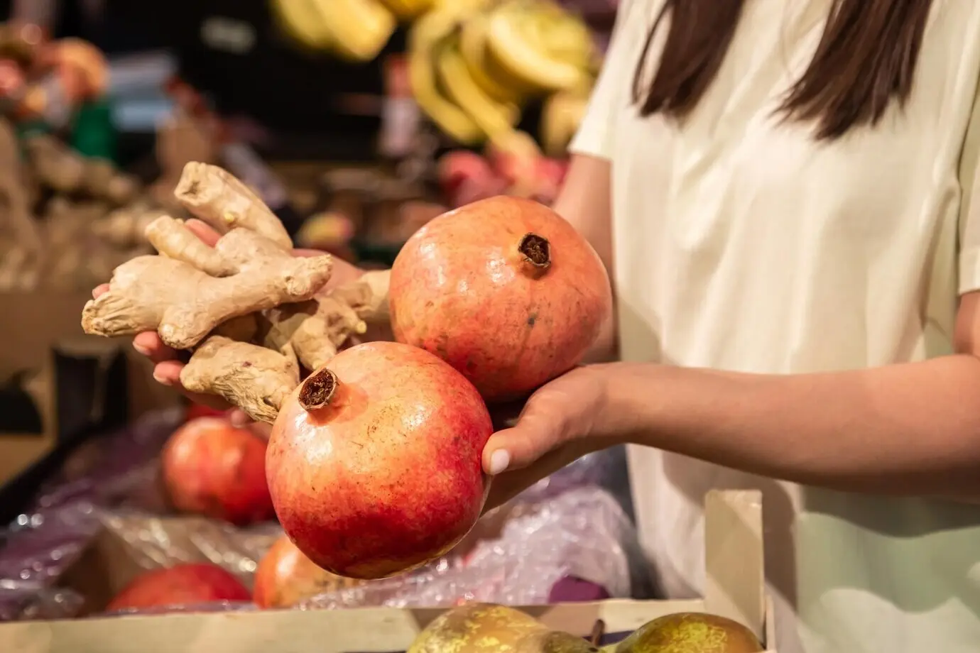 In Nahaufnahme hält die Frau im Laden oder auf dem Markt einen Granatapfel.